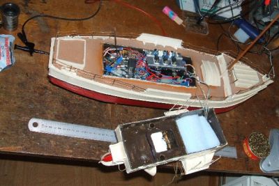 bacchus 6
les entrailles de la chose; comme vous pouvez le constater, c'est plein. En effet, la récupération ne permet de faire le difficile. On fait avec. Le récepteur (découpé sur un récepteur de voiture pour enfants) et le décodeur sont sous la mousse du roof (d'où les fils); ce qu'on voit, ce sont les servos moteurs hand made et les chargeurs. Il suffit de brancher bacchus sur une batterie externe (entre 8 et 20 V) et il se débrouille. On n'arrête pas le progrès
