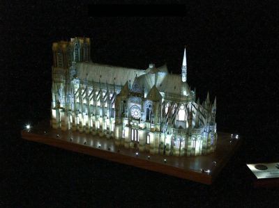 CathÃ©drale N.D. de Reims, primÃ©e 2 fois
Â·	Principe :

o	A partir dâ€™un cahier de maquette de lâ€™Instant Durable Ã©chelle 1/250Ã¨me , rÃ©alisation dâ€™un cahier de maquette au 1/300Ã¨me pour permettre la comparaison avec les autres maquettes de la collection et augmenter la miniaturisation.
o	Reconstitution des reliefs par collage de couches successives des motifs
o	Reconstitution exacte des 70 vitraux de la cathÃ©drale par photographie numÃ©rique sur place des vitraux, rectification, mise Ã  lâ€™Ã©chelle et insertion des transparents dans la maquettes.

Conception rÃ©alisÃ©e en DAO, logiciels utilisÃ©s :
o	 Adobe Photoshop 7

Â·	Conception et rÃ©alisation des  Ã©clairages intÃ©rieurs et extÃ©rieurs

Â·	MatÃ©riaux utilisÃ©s
o	Film transparent pour photocopies couleur ( Vitraux)
o	Papier blanc 180 gr 
o	Bois du support : chÃªne

Â·	MatÃ©riels Ã©lectriques utilisÃ©s
o	1 programmateur  cyclique 5 pistes pour assurer les sÃ©quences dâ€™Ã©clairage
o	1 alimentation 12 V = Pour lâ€™alimentation des leds et des mini tubes fluorescents
o	minis tubes fluo 12 V couleur blanche
o	Leds pour les Ã©clairages intÃ©rieur et extÃ©rieur
o	1 lampe PAR 12 V 50 W pour lâ€™Ã©clairage diurne avec son alimentation Ã©lectronique



